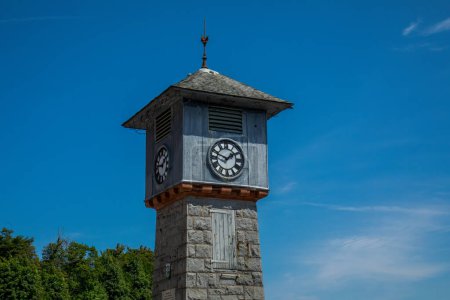 Téléchargez les photos : Tour d'horloge du centre-ville à Tobermory, île de Mull au soleil avec un beau fond bleu ciel - en image libre de droit