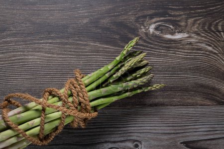 Asparagus on blue dish on black background with cocos rope