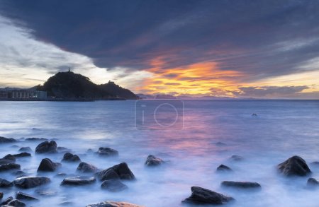 Téléchargez les photos : Nuage rouge au coucher du soleil sur la côte de Donostia-San Sebastian, Euskadi - en image libre de droit