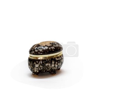Téléchargez les photos : Petite boîte à bijoux en céramique noire et blanche avec anneau doré autour du cou isolé sur fond blanc - en image libre de droit