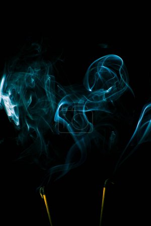 Téléchargez les photos : La fumée d'encens crée une variété de formes de motifs sur un fond noir mise au point sélective faible profondeur de la photographie de terrain - en image libre de droit