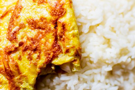 Téléchargez les photos : Omelette d'oeuf pliée conservée sur le riz chaud dans une assiette à manger saine habitude alimentaire indienne - en image libre de droit