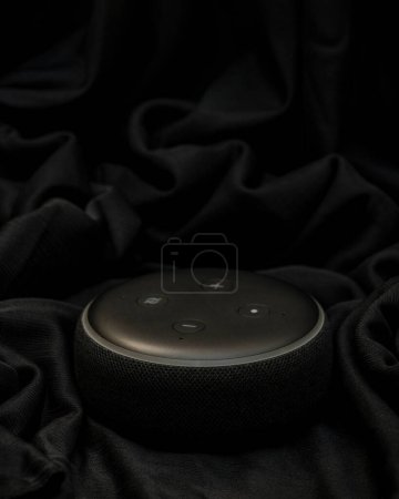 Foto de Bankura, Bengala Occidental, India - 24 de septiembre de 2022: Amazon Echo Dot tercera generación con altavoz Alexa Smart Wi-Fi incorporado Negro con pliegues de tela negra fotografía de estudio de fondo - Imagen libre de derechos