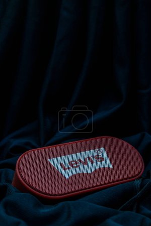 Photo for Bankura, West Bengal, India - September 24, 2022: Levi's Bluetooth speaker with FM radio place into folds of a black satin cloth studio photography. - Royalty Free Image