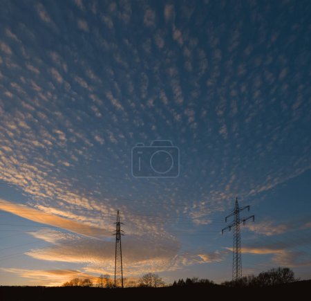 alto - torre de voltaje con un hermoso cielo al atardecer en el fondo. foto de alta calidad