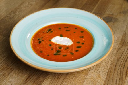 Téléchargez les photos : Vue grand angle de la soupe aux tomates avec burrata et pesto maison sur une table en bois. - en image libre de droit