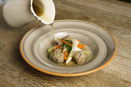 Goose soup consomm with dumplings and vegetables