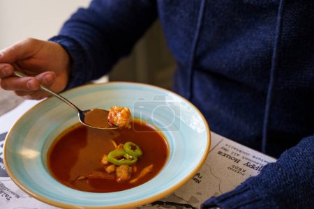 Téléchargez les photos : Une personne qui mange de la soupe de poisson hongroise avec poisson-chat - en image libre de droit