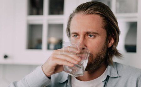 Photo for Man Holding Glass Drinking Still Water, and maintains the body's water balance. Close up. - Royalty Free Image