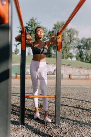 Téléchargez les photos : Portrait de jeune femme africaine en forme mince sur un terrain de sport lors d'une journée ensoleillée. - en image libre de droit