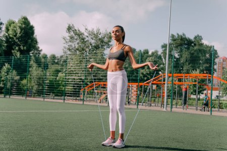 Foto de Concepto de fitness y estilo de vida - mujer haciendo deportes al aire libre. chica con saltar la cuerda - Imagen libre de derechos