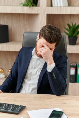 Foto de Un ejecutivo o un oficinista cerrando los ojos ante el cansancio, el dolor de cabeza y la migraña - Imagen libre de derechos