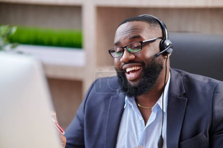 Photo for Representive African American practitioner leads online training wearing a suit and headset, active gestures and explanations - Royalty Free Image