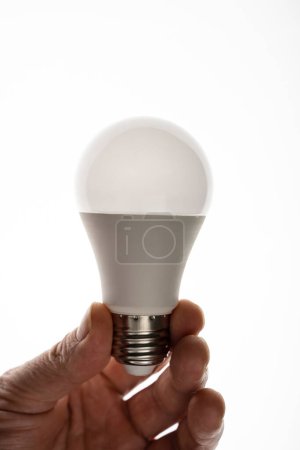 Téléchargez les photos : Un homme tient une ampoule LED. Ampoule LED à économie d'énergie. - en image libre de droit