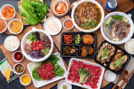 Téléchargez les photos : Nourriture coréenne, boeuf coréen, sashimi de boeuf, Handon, sashimi de boeuf, ventre de porc cru, feu de bois, assaisonnement, côtes, plats d'accompagnement, galbitang, riz, kimchi, ssamjang, piments, ail, choux de radis, laitue - en image libre de droit