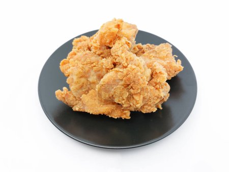 Foto de Montón de pollo frito crujiente en un plato negro, aislado sobre fondo blanco con espacio para copiar. Enfoque selectivo. - Imagen libre de derechos