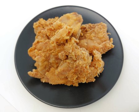 Foto de Montón de pollo frito crujiente en un plato negro, aislado sobre fondo blanco con espacio para copiar. Vista superior. - Imagen libre de derechos