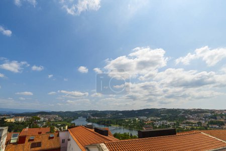 Foto de Una vista de la ciudad de Coimbra bajo un hermoso cielo despejado, con el río Mondego, árboles y edificios. Fondo de paisaje y fondo de pantalla. - Imagen libre de derechos