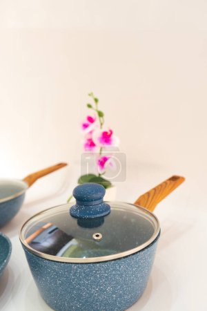 Foto de La olla antiadherente azul y la bandeja de teflón con mango de madera es un conjunto de utensilios de cocina versátil y conveniente que combina la funcionalidad con el estilo. - Imagen libre de derechos