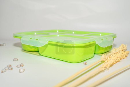 Foto de La caja de almuerzo de plástico verde es una solución de almacenamiento de comida conveniente y práctica.. - Imagen libre de derechos