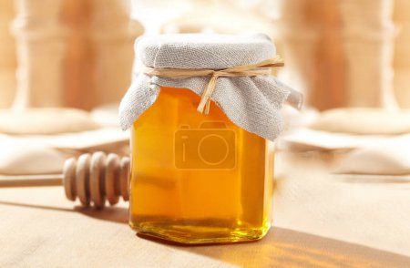 Photo for Honey Jar with a wood stick in a blurred background - Royalty Free Image