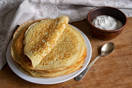 Pancake. Pancakes stack with sour cream, traditional Russian pancakes - blini on wooden background
