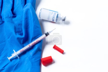 Téléchargez les photos : Gants médicaux et seringue avec flacon en verre sur fond blanc. - en image libre de droit