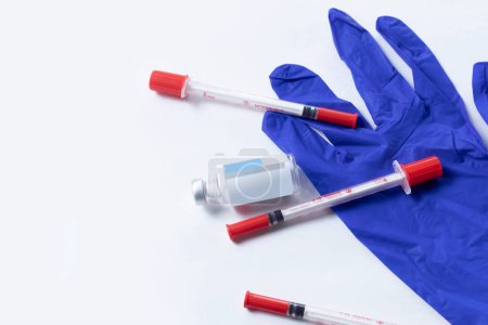 Téléchargez les photos : Flacon médical avec seringue sur fond blanc avec gants bleus - en image libre de droit