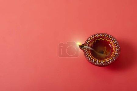 Glückliche Diwali und Kartika Deepam Festival Grußkarte - Bunte Ton-Diya-Lampen auf rotem Hintergrund