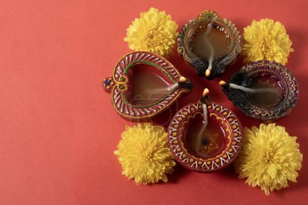 Foto de Happy Diwali y Karthika Deepa - Coloridas profundidades de arcilla con flores Fondo - Imagen libre de derechos