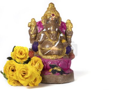 Photo for Vinayaka Chaturthi - Ganesh statue made of clay with yellow flowers on white background. - Royalty Free Image