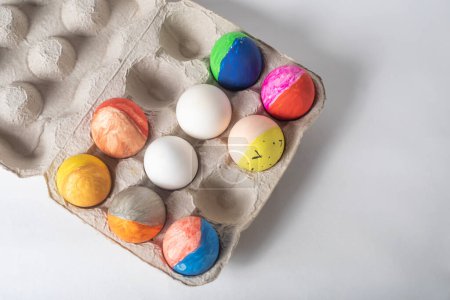 Photo for Colorful Easter eggs on a cardboard tray on a white background - Royalty Free Image