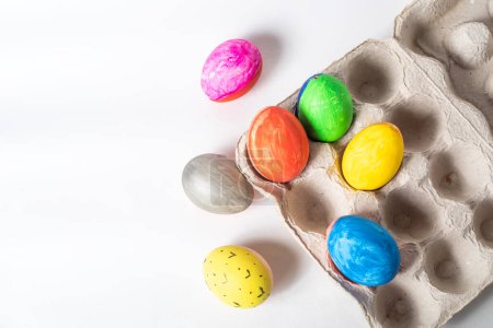 Photo for Top view of colorful easter eggs in cardboard box on white background with copy space - Royalty Free Image
