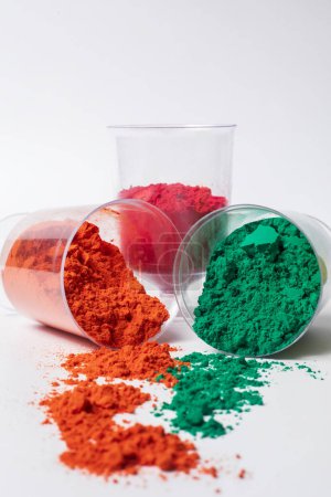 Colorful holi powder in a glass container isolated on white background. Indian festival Holi
