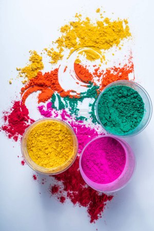 Colorful holi powder in glass bowl isolated on white background. Top view