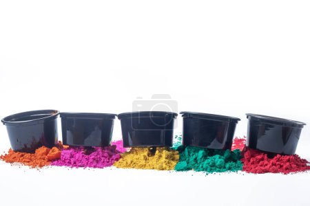 Colorful holi powder in black plastic buckets isolated on white background.