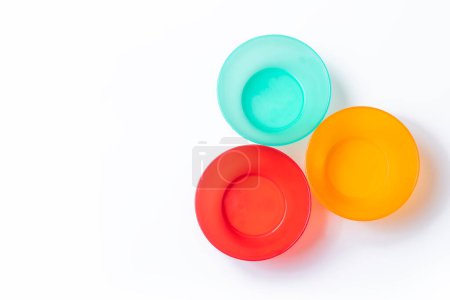 Téléchargez les photos : Ensemble de vaisselle en plastique vibrant isolé sur fond blanc avec espace de copie. Vue du dessus. - en image libre de droit