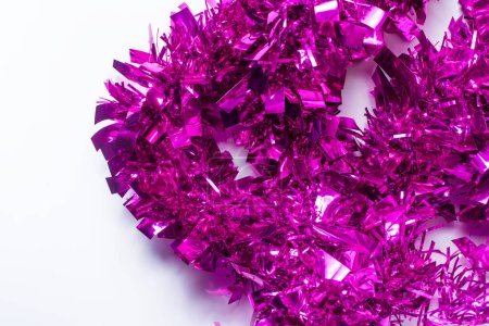 Purple tinsel on a white background. Concept of Christmas and New Year.