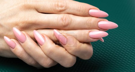 Photo for Stylish trendy nail young woman hands pink manicure on dark background - Royalty Free Image