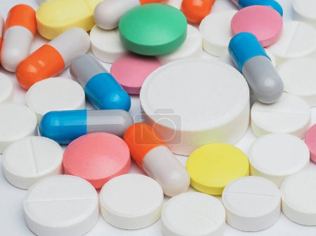 Foto de Comprimidos redondos sobre fondo blanco. Un montón de pequeñas medicinas redondas se cierran. Concepto de salud y medicina. - Imagen libre de derechos