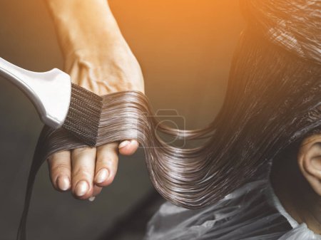 Téléchargez les photos : Gros plan de coloriste teint les cheveux de la femme avec brosse et feuille dans le salon de beauté - en image libre de droit