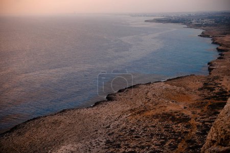 Foto de Tarde sobre azul oscuro mediterráneo, rocas y la naturaleza de Chipre. Relajación pacífica en Ayia Napa durante el verano. - Imagen libre de derechos