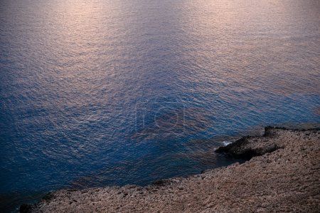 Foto de Hermosa vista desde el alto acantilado rocoso sobre el mar mediterráneo azul oscuro en Ayia Napa durante el tiempo de la noche. Concepto de verano, viajes y vacaciones. - Imagen libre de derechos