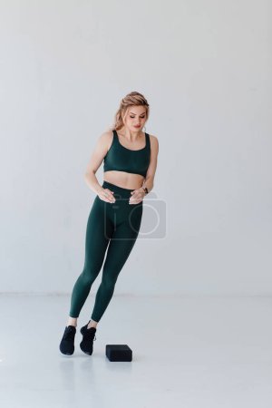 Photo for Vertical view of the athletic woman jumping over barrier. Pilates distance learning, studying fitness concept - Royalty Free Image