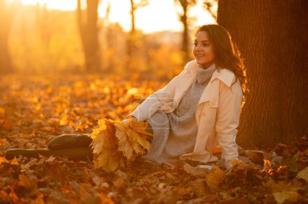 Téléchargez les photos : Portrait complet de belle femme d'automne debout avec des feuilles d'automne colorées. Assez heureux modèle joyeux regardant loin - en image libre de droit