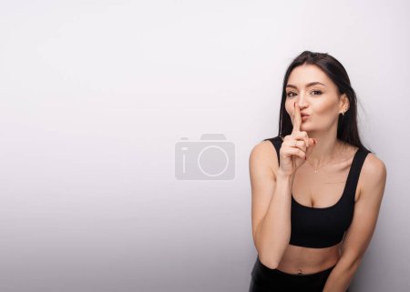 Téléchargez les photos : Shh, be quiet. Portrait of woman showing silence gesture with finger on her mouth, asking to stay quiet, keep secret. Indoor studio shot isolated on white background - en image libre de droit