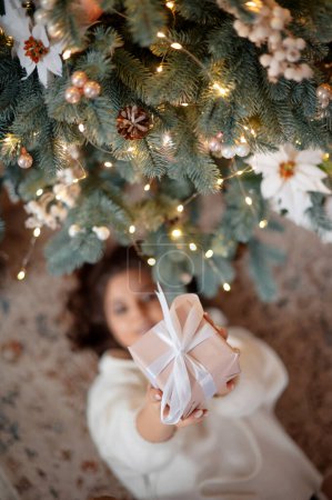 Téléchargez les photos : Vue de dessus de la belle jeune fille posant arbre de Noël dans la maison en bois d'hiver. Temps de Noël, et heureux nouveau concept thématique de l'année - en image libre de droit