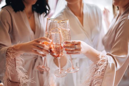 Téléchargez les photos : Vue rapprochée des mains féminines tenant des verres avec du vin ou du champagne. Demoiselles d'honneur et mariée célèbrent le jour du mariage - en image libre de droit