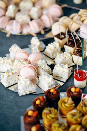 Foto de Buffet de catering con diferentes tipos de dulces y golosinas para eventos. Macarrones rosados de cerca - Imagen libre de derechos