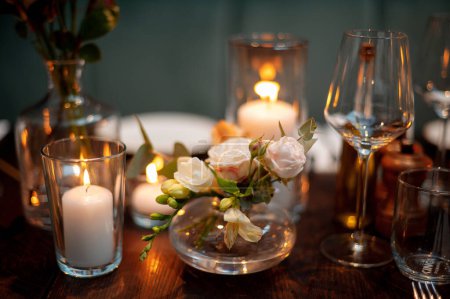Foto de Acogedor ajuste de mesa de boda con velas y flores de cerca. Decoración de la boda. - Imagen libre de derechos